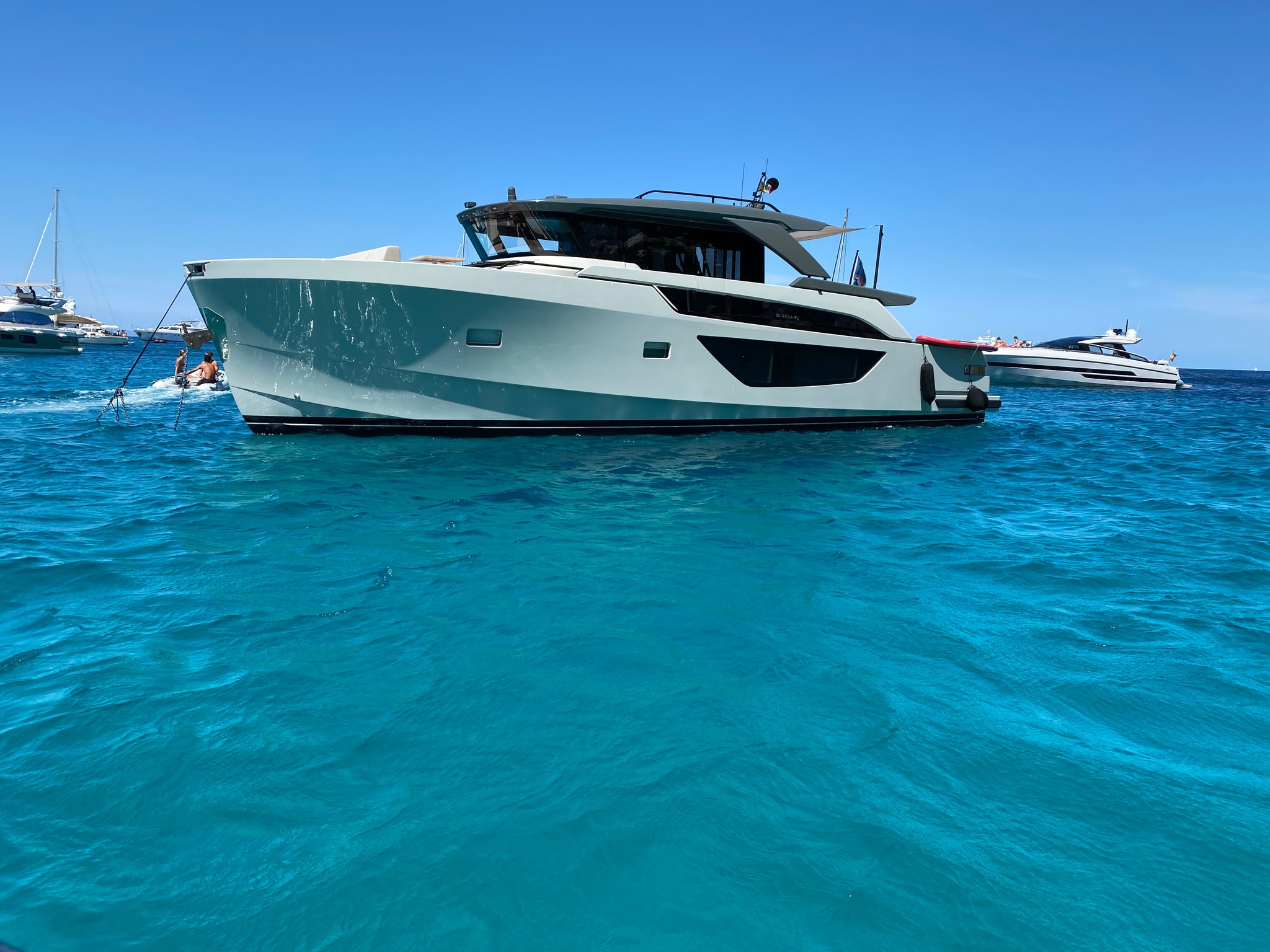 A pale motor yacht on turquoise water
