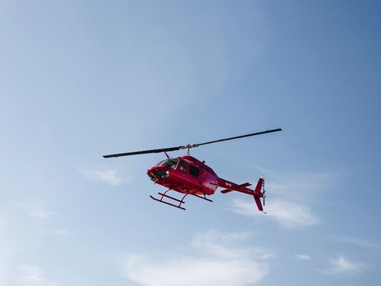 A red helicopter in a clear sky