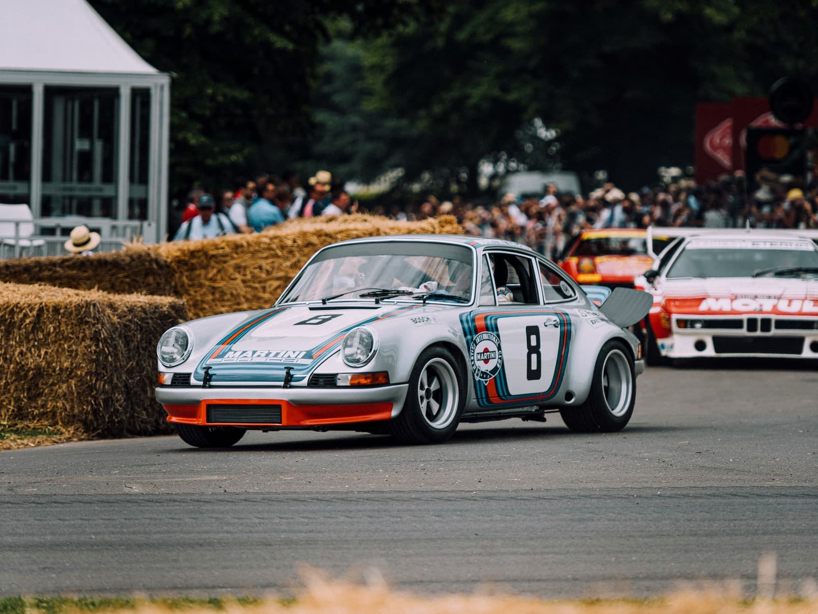 A classic racing car at a crowded motorsport event