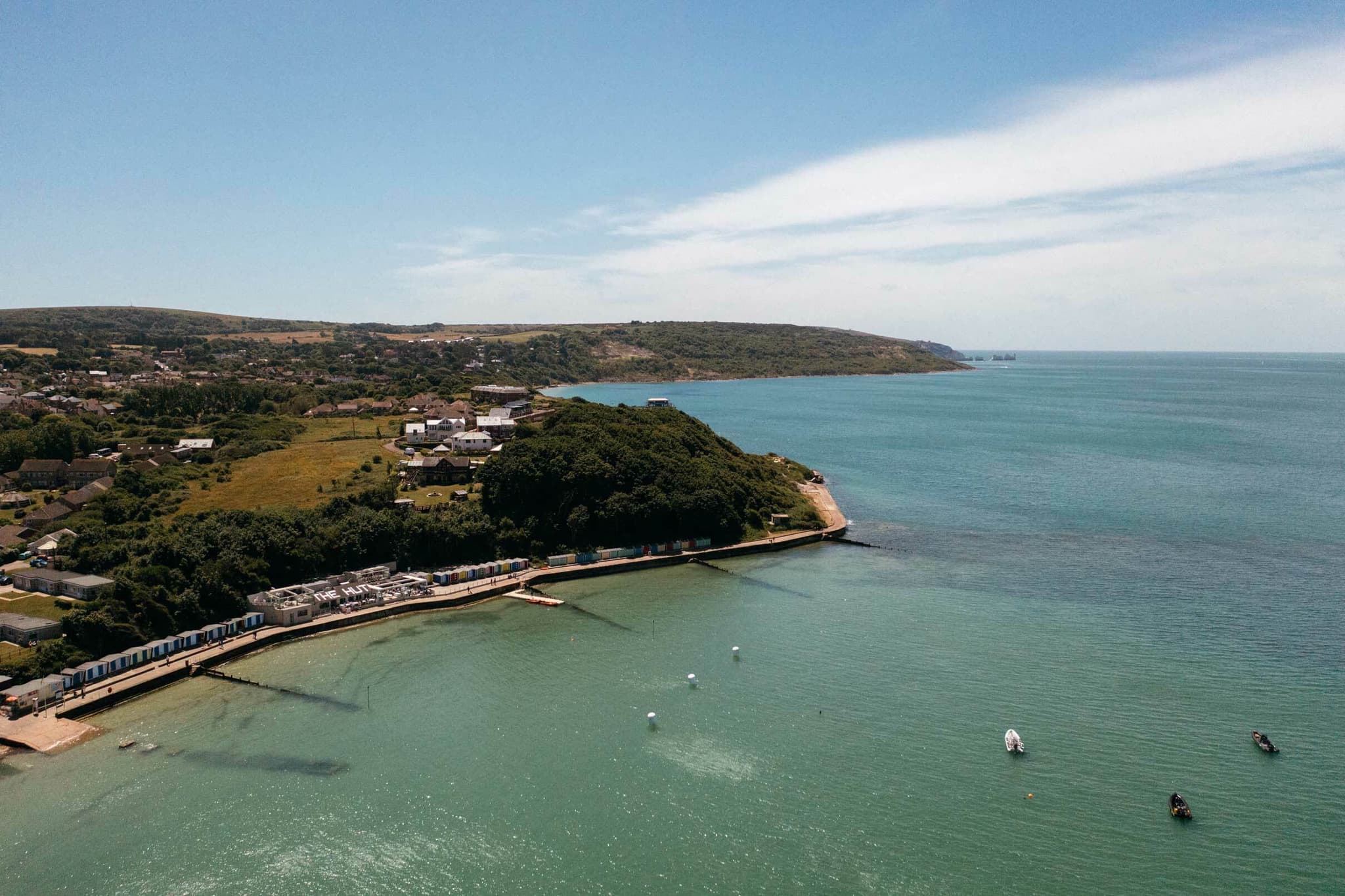 Aerial view of Colwell Bay on the Isle of Wight, showing The Hut restaurant beside the waterfront and the surrounding coastline.