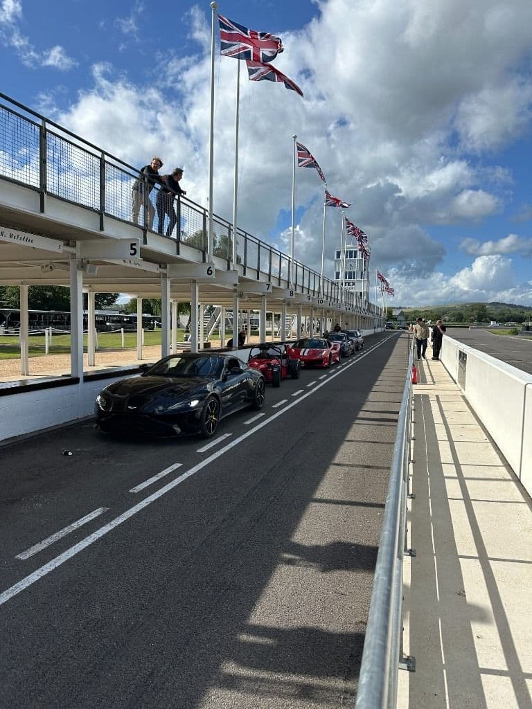 Sports cars lined up in a pit lane
